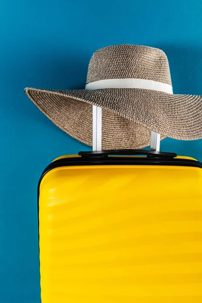 Bright and stylish cabin size suitcase with straw hat