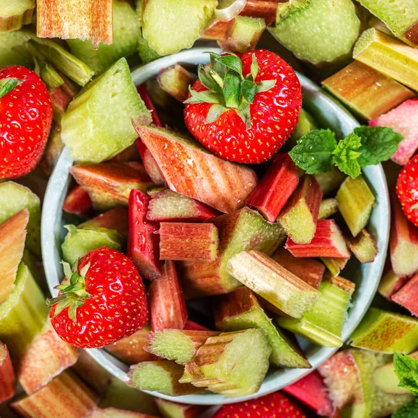 Close-up van stukjes rauwe en vers gesneden rabarber en aardbeien — Stockfoto