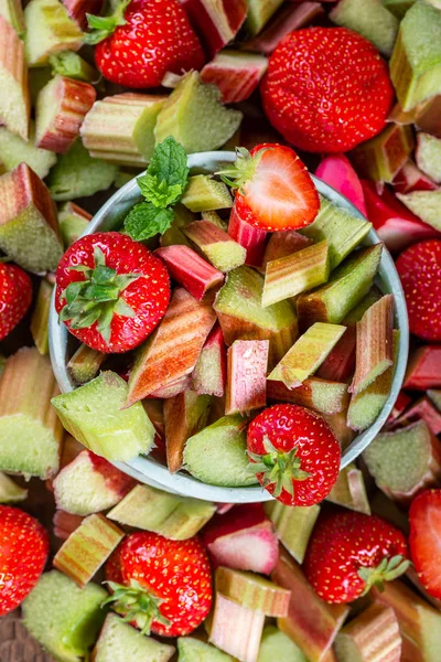 Close-up van stukjes rauwe en vers gesneden rabarber en aardbeien — Stockfoto