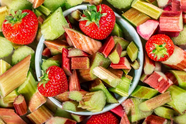 Close-up van stukjes rauwe en vers gesneden rabarber en aardbeien — Stockfoto