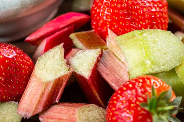 Close-up van stukjes rauwe en vers gesneden rabarber en aardbeien — Stockfoto