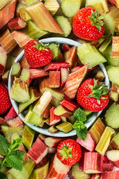 Gros plan de morceaux de rhubarbe et de fraises crues et fraîchement coupées — Photo