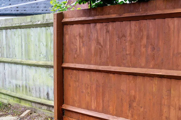 Malowanie starych drewnianych ogrodzeń z brązową farbą — Zdjęcie stockowe