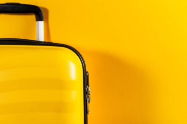 Parlak sarı arka planda parlak ve şık kabin boyutu bavul