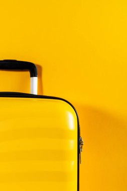 Parlak sarı arka planda parlak ve şık kabin boyutu bavul