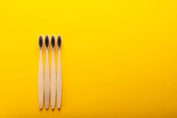 Un conjunto familiar de cuatro cepillos de dientes de bambú de madera — Foto de Stock