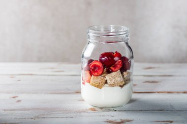 Jar taze kiraz meyveleri ile rendelenmiş buğday Bitesize