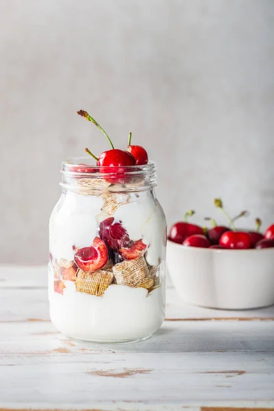 Menggigit serpihan gandum dengan buah ceri segar di Jar — Stok Foto