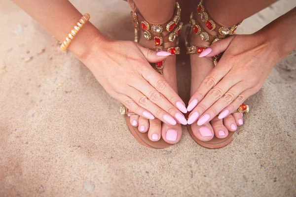 Az ifjú hölgy világos rózsaszín manikűr-és pedikűr körmöket mutat — Stock Fotó