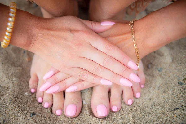 Az ifjú hölgy világos rózsaszín manikűr-és pedikűr körmöket mutat — Stock Fotó