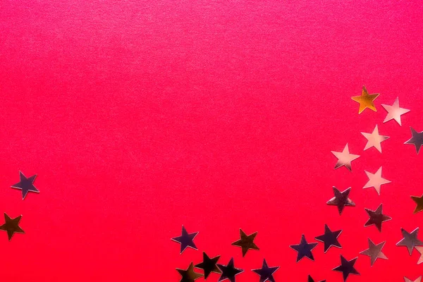 Parlak kırmızı arkaplanda altın yıldızlar — Stok fotoğraf