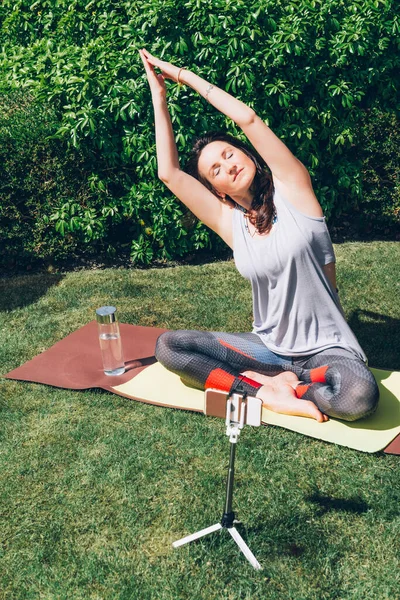 Woman is doing yoga in garden — Stock Photo, Image