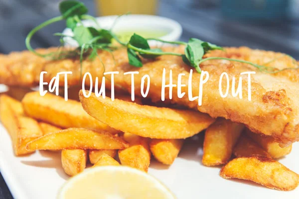 Eat Out to Help Out phrase. Traditional English Food such as Fish and Chips with green mushy peas served in the Pub or Restaurant