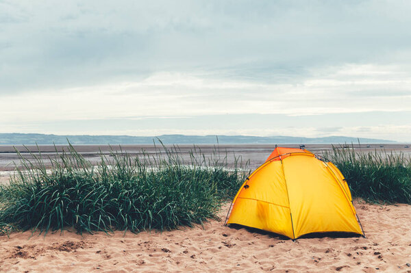 Яркая желтая палатка на пляже