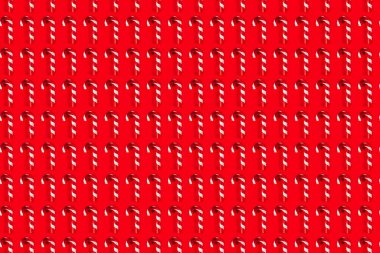 Kırmızı arkaplanda Cam Şeker Çubukları şeklinde yapılmış Noel Ağacı Dekorasyonları deseni, üst görünüm, kopyalama alanı