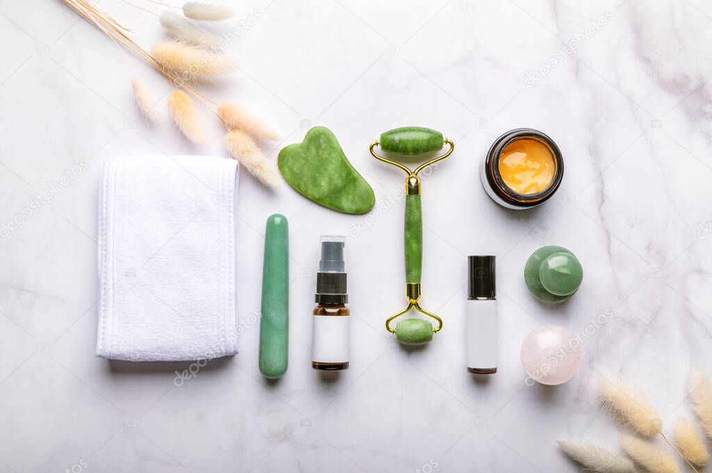 Set of Gua Sha massage tools for beauty facial therapy, Skin Care Anti-Aging Tools such as Green Aventurine and Rose Quartz Mushrooms, Wand, Jade face roller, stone and bottles of cosmetics
