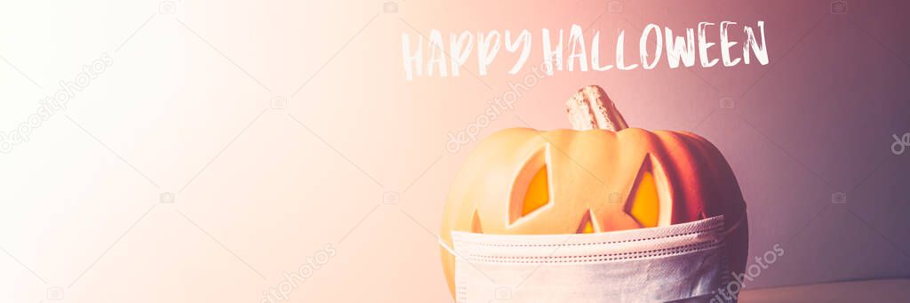 Happy Halloween 2020 text. Orange Pumpkin or Halloween Jack o Lantern in medical protective mask, halloween and covid-19 concept. New Normal and New reality concept. banner size