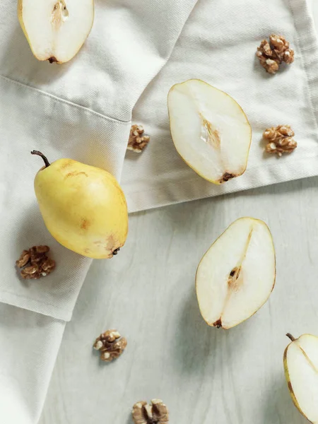 Yarım armut dilimli taze sarı kesim ve lamba masasında ceviz. Yukarıdan görüntüle.