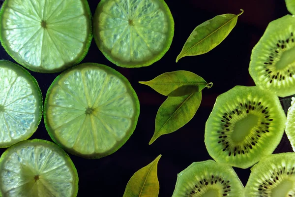 Koyu arka planda parlak yeşil kireç dilimlerinin yakın plan fotoğrafı. Üst görünüm.