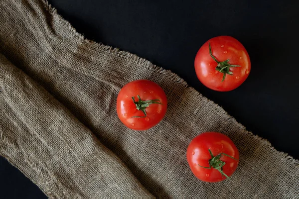 Koyu kırsal bir arka planda ıslak domateslerin üst görüntüsü