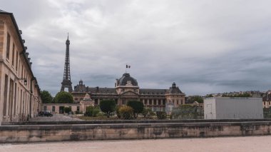 Paris 'te bulutlu bir gün, arkadan Eyfel kulesi ve karamsar renklere sahip diğer geleneksel binalar.