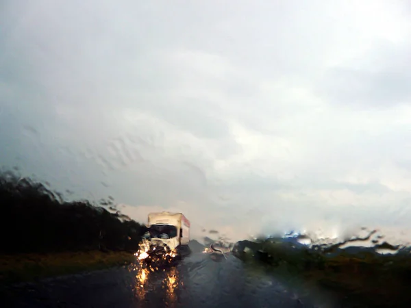 Araba yağmurda otoyolda gidiyor.