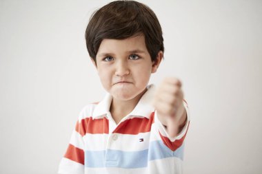 Angry kid with a thumbs down gesture clipart