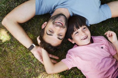 Oğul ve baba çim üzerinde yalan portre