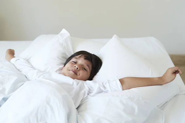 Stretching Pojke Sängen Ser Att Kameran — Stockfoto