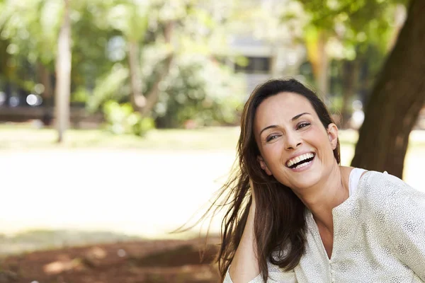 Carefree brunette woman  laughing in park