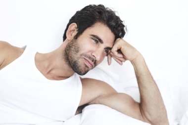 Uzakta görünen düşünceli adam yatakta,