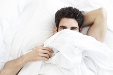 Adam kameraya yatağından seyir yorganın altında