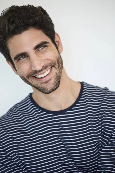 Smiling blue eyed guy ins striped top, looking away