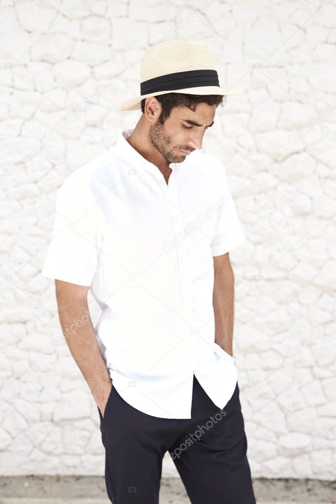 Handsome man in hat and shirt, looking down