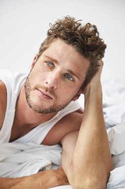 Mavi gözlü adam yatakta yatan