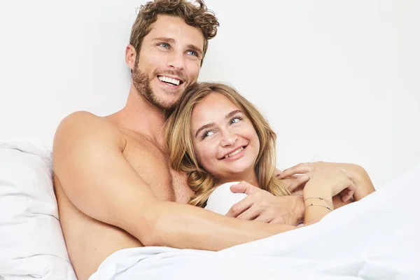 年轻夫妇一起在床上微笑 — 图库照片