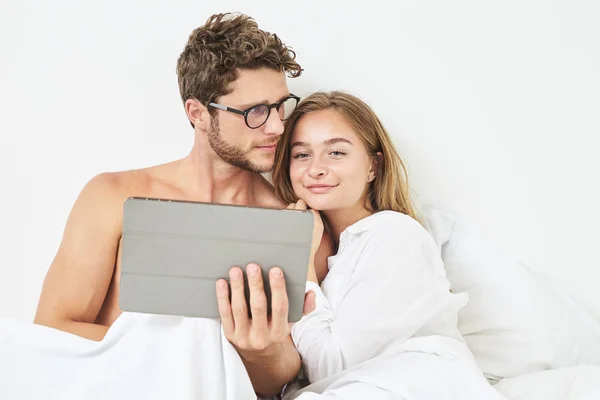 Young couple planning with tablet in bed