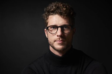 Studio, gözlük adam kameraya bakıyor