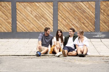 Birlikte sokakta oturan, gülümseyen çiftler