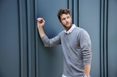 Adam gri mavi duvara yaslanmış