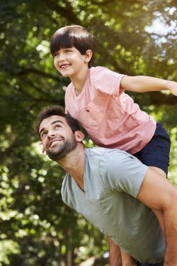 Baba ve oğul parkta oynarken gülümseyen