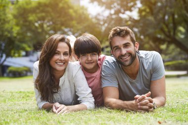 Anne, baba ve oğul parkta gülümseyen