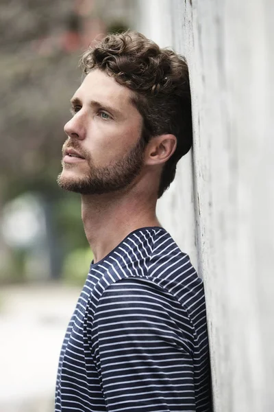 Dude leaning against wall in striped top