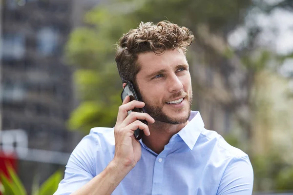 Young dude in blue on call in city