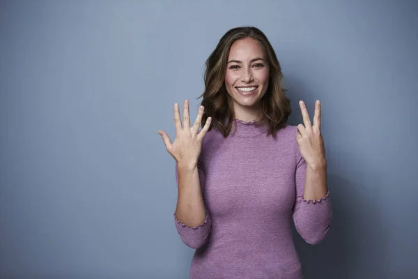 Güzel Kadın Yedi Göstermek Için Parmaklarını Kullanarak Stüdyo — Stok fotoğraf