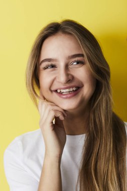 Sarı arka plana karşı genç bayan gülüyor