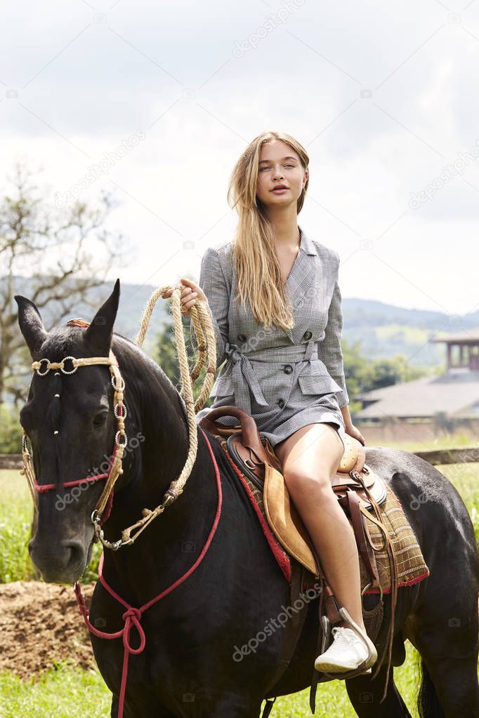 Pretty young woman on horse, looking to camera