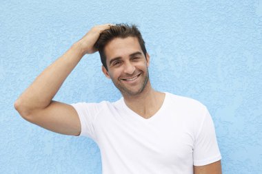 Mavi arka plan beyaz gömlek gülümseyen adam