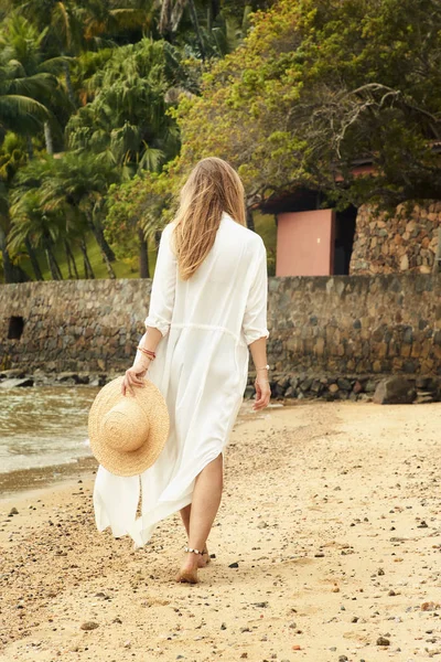 Barefoot babe on beach walking away