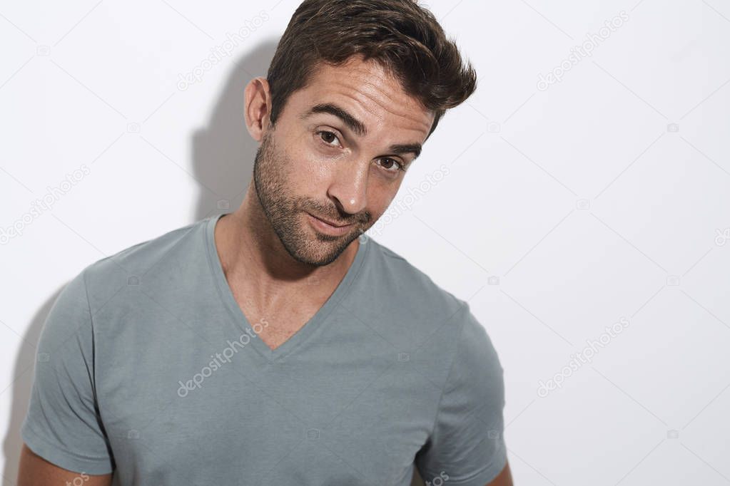 Portrait of stubble guy in grey against white